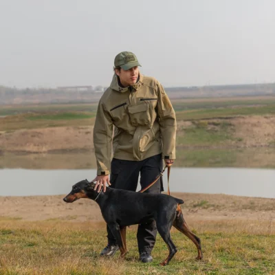 Man wearing waterproof jacket while walking dog outdoors, showing waterproof and windproof functionality in real use.