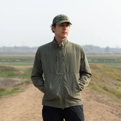 Outdoor model wearing army green lightweight jacket, ideal for hiking, trekking, and everyday outdoor work.