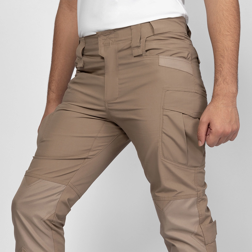 Close-up of khaki waterproof hiking pants showing flexible fabric, cargo pocket design, and reinforced seams ideal for outdoor adventures.