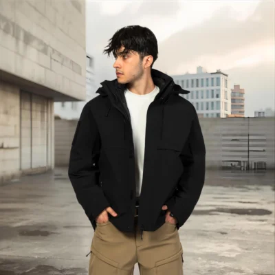 Black 3 in 1 waterproof jacket for men shown in an urban outdoor setting, featuring windproof shell and removable fleece lining for all-weather protection.
