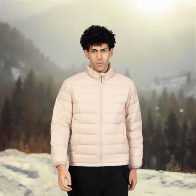 Beige lightweight down jacket for men photographed in outdoor winter setting, featuring thermal insulation and minimalist design for everyday wear.