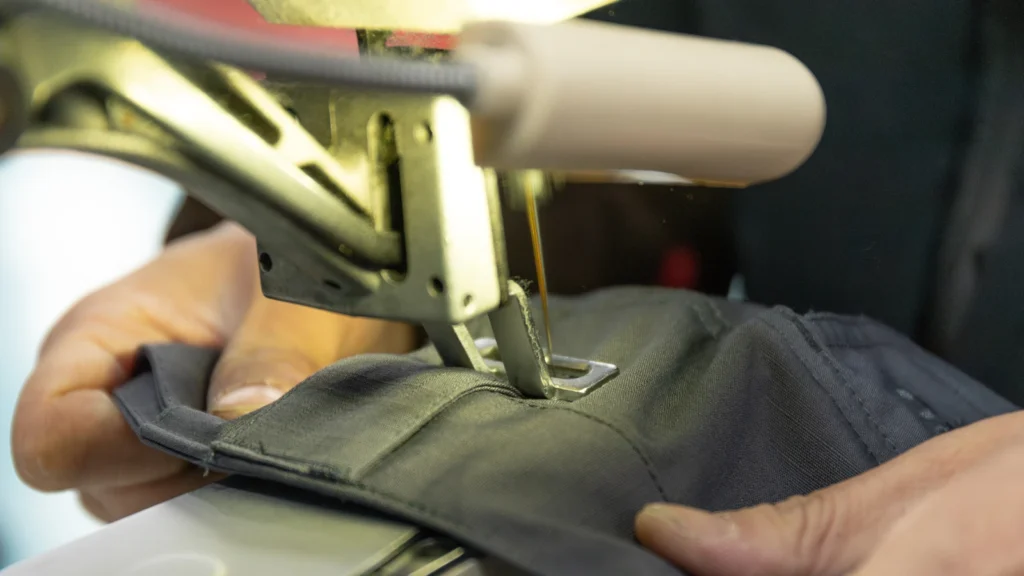 Tactical pants being sewn on industrial sewing machine at Frontergroup manufacturing facility, China